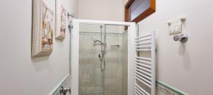 a bathroom with a shower with a glass door at La stanza della nonna in Modica