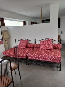 una sala de estar con 2 sofás rojos y una silla en Maison à contes, en Contes