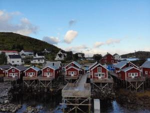 a village with red houses and a bridge in the water at Madelhea Cabin- Seaview Lodge in Reine