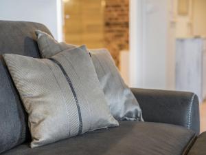 a gray couch with two pillows on it at Speicher Hafendomizil in Barth