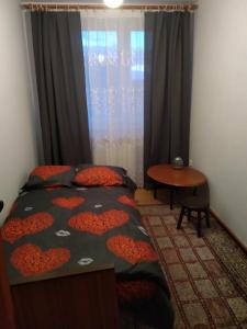 1 dormitorio con cama, mesa y ventana en Domek w spokojnej podlaskiej wsi, en Czerwonki