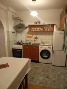 a kitchen with a white refrigerator and a washing machine at Domek w spokojnej podlaskiej wsi in Czerwonki