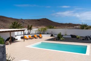 een zwembad in een patio met een berg op de achtergrond bij Casa Monicha in Costa Teguise