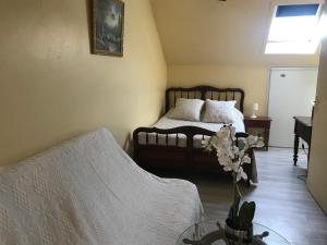 - une chambre avec un lit et une table ornée d'un vase de fleurs dans l'établissement chambre d'hotes chez christiane, à Lourdes