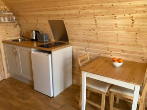 a small kitchen with a table and a sink at Kirkapol Beach Pod - Ebb in Middleton