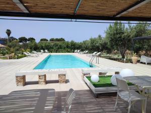 a swimming pool with a table and chairs next to at Inkantu B&B in Terrasini
