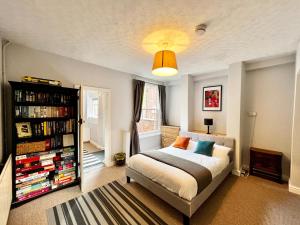 ein Schlafzimmer mit einem Bett und einem Bücherregal mit Büchern in der Unterkunft 14 Union Road in Lincolnshire