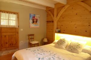a bedroom with a bed and a wooden wall at L'Aire du temps Savoyard in Ugine