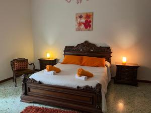 una camera da letto con un letto con due cuscini arancioni sopra di Rua House a Corleone