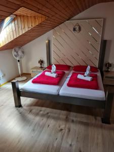 1 dormitorio con 2 camas con sábanas rojas y ventilador en Rustikale Wohnung mit Garten, en Allensbach