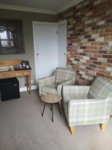 a living room with two chairs and a table at Greystones guesthouse in Whitby