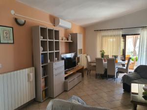 a living room with a television and a dining room at Kuća za odmor Tanja in Vir