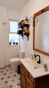 Un baño con lavabo, inodoro y espejo. en Casco antiguo con patio y a 5 min de la playa, en Baiona 13 fotos más