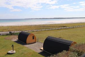 a couple of tents sitting on top of a beach at Kirkapol Beach Pod - Flow in Middleton