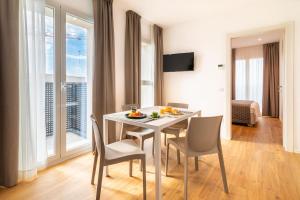 a dining room with a table and chairs in a room at Superior Beach Aparthotel in Lido di Jesolo