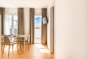 a dining room with a table and chairs and a window at Superior Beach Aparthotel in Lido di Jesolo