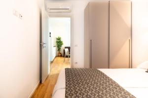 a bedroom with white walls and a bed and a hallway at Superior Beach Aparthotel in Lido di Jesolo