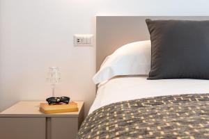 a bedroom with a bed and a night stand with a lamp at Superior Beach Aparthotel in Lido di Jesolo