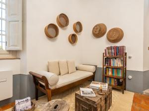 sala de estar con sofá y placas en la pared en PALAZZO CHERCHI, en Dorgali