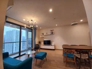 een woonkamer met een tafel en blauwe stoelen bij Angela House Ha Long in Ha Long