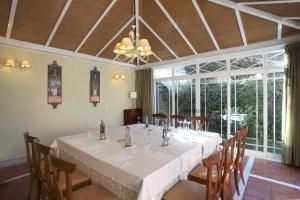 a dining room with a white table and chairs at La Quinta de los Cedros in Madrid
