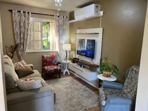 een woonkamer met een bank en een tv bij Apartamento Catedral Canela in Canela