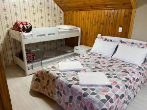een slaapkamer met een bed en een stapelbed met handdoeken bij Apartamento Catedral Canela in Canela