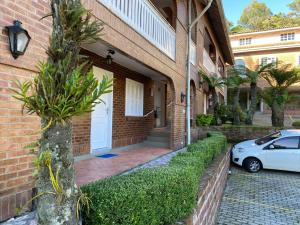 een witte auto geparkeerd voor een bakstenen huis bij Apartamento Catedral Canela in Canela