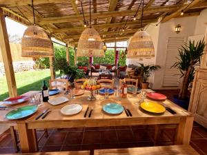 a wooden table with plates and utensils on it at VILLA BINISABEL NOU, CONFORT Y EXCLUSIVIDAD in Sant Lluis +30 photos