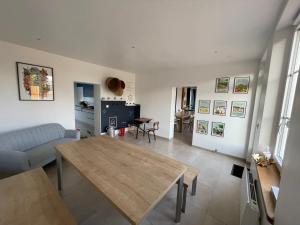 a living room with a table and a couch at La Maison des Jonquerets in Jonquerets-de-Livet