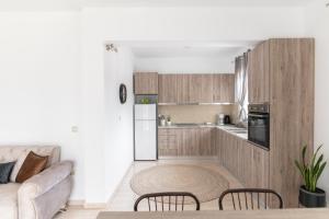 een keuken en een woonkamer met een bank en een tafel bij Oliva Apartments in Mákri