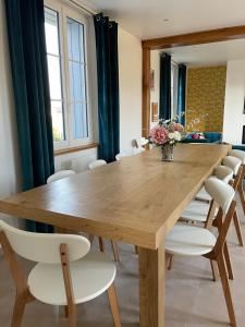 a dining room with a wooden table and chairs at La Maison des Jonquerets in Jonquerets-de-Livet +42 photos