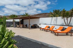 - un ensemble de chaises longues orange sur la terrasse dans l'établissement Casa Monicha, à Costa Teguise