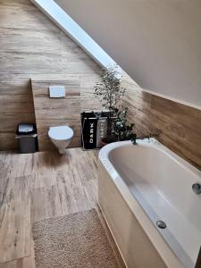 a bathroom with a bath tub and a toilet at Dom nad jeziorem - MAZURY in Szczytno
