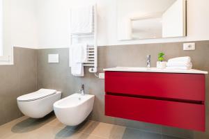 a bathroom with a red cabinet and a toilet at Superior Beach Aparthotel in Lido di Jesolo