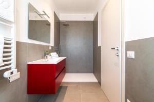 a bathroom with a red sink and a shower at Superior Beach Aparthotel in Lido di Jesolo