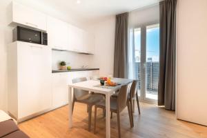 a kitchen and dining room with a table and chairs at Superior Beach Aparthotel in Lido di Jesolo