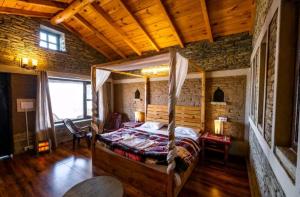 a bedroom with a canopy bed in a room at Meraki Huts in Pauri