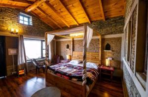 um quarto com uma cama de dossel num quarto em Meraki Huts em Pauri