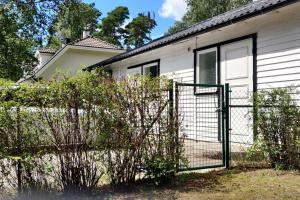 a fence in front of a white house at On your way in Löddeköpinge