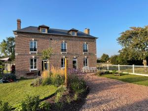 an old brick house with a garden in front of it at La Maison des Jonquerets in Jonquerets-de-Livet