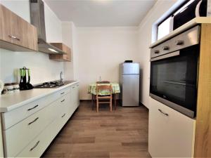 a kitchen with white cabinets and a large appliance at Apartments Morena in Rakalj