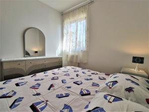 a bedroom with a bed with a blue and white comforter at Apartments Morena in Rakalj