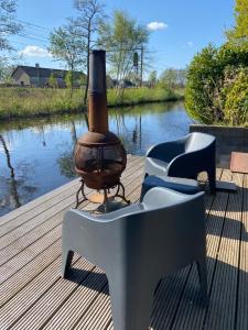 einem Grill, der auf einem Deck neben einem Wasserkörper sitzt in der Unterkunft BzB Jantina in Heerenveen