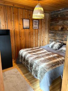 a bedroom with a bed in a log cabin at Kelokuura Ruka in Ruka