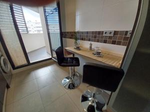 a small kitchen with a table and two chairs at Magnífico apartamento en El Pto de Sta María, aire acc, piscina, zona niños y padel in El Puerto de Santa María