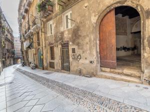 um beco num edifício antigo com uma porta aberta em Lamarmora 26 em Cagliari