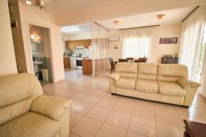 a living room with two couches and a kitchen at Cheerful 3 bdr villa near the beach in Coral Bay