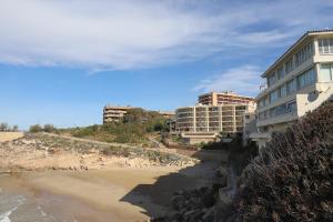 サロウにあるDIFFERENTFLATS Cala Llenguadetsのホテルと建物のあるビーチの景色を望めます。