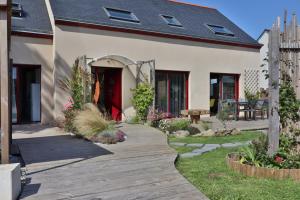 une maison avec une passerelle en bois dans la cour dans l'établissement Kerlobek Albacore, à Groix